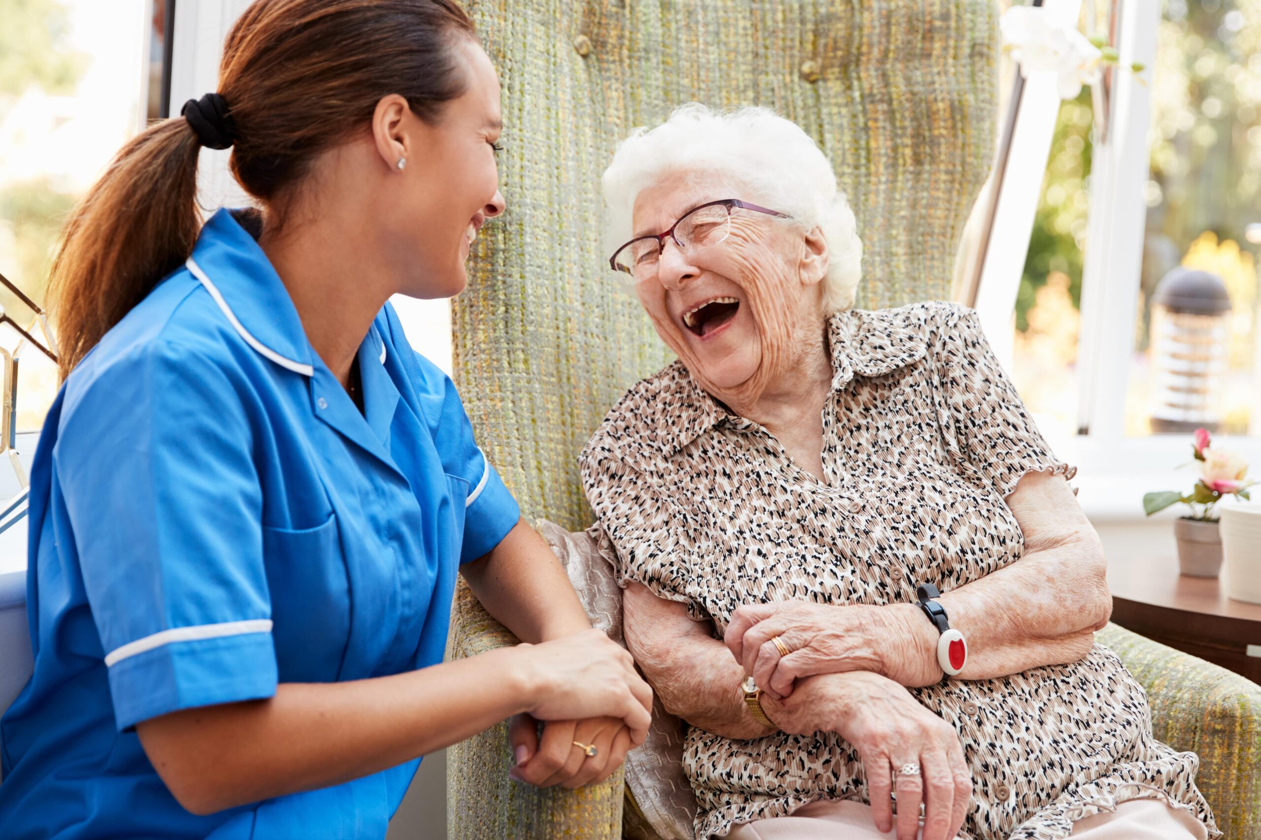 Live-in carer laughing with patient