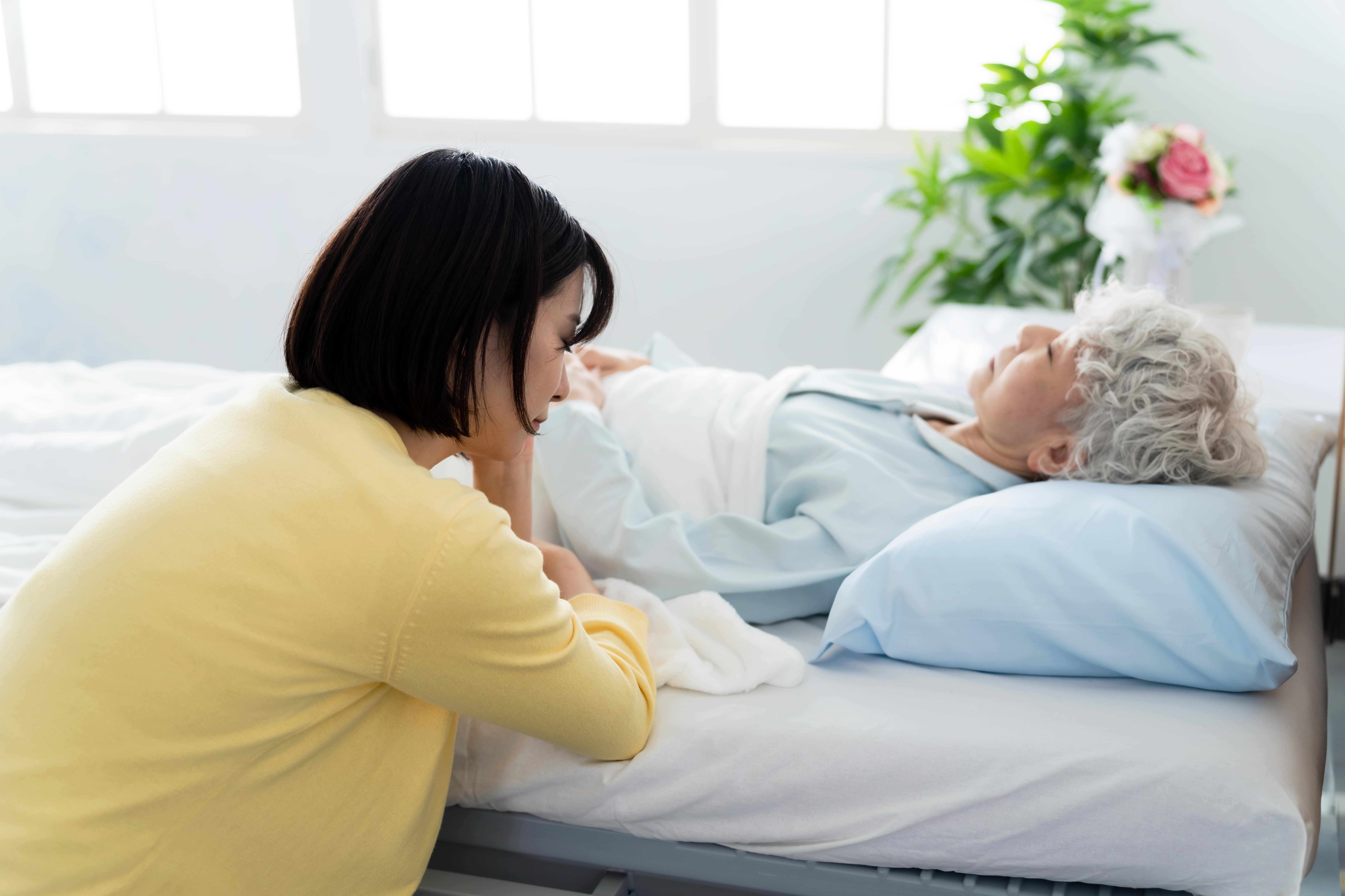 24-hour carer stressed on bed side