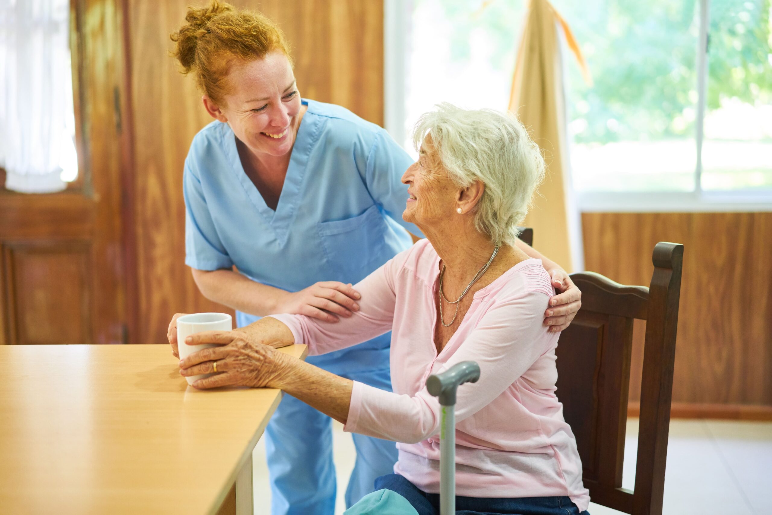 smiling live-in carer looking after elderly woman.